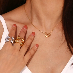 Détail de bagues goutte d'eau dorées et argentées avec collier pendentif en cœur