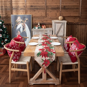Christmas table runner with red poinsettia pattern and matching holiday throw pillows