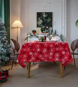 Macro view of Christmas red tablecloth featuring festive white snowflake prints and texture