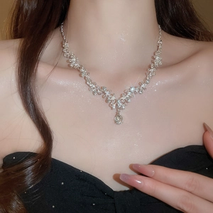 Close-up of silver drop pendant necklace with shimmering crystals on a female model