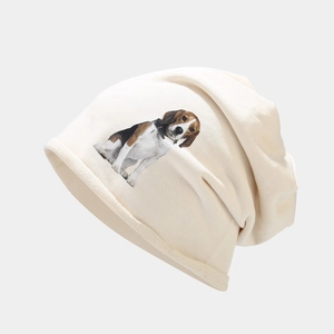 Détail du bonnet en maille beige avec imprimé beagle et texture de tissu doux