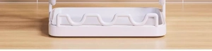 Close-up of the wavy support structure on white kitchen lid organizer base