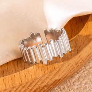 Macro shot of silver adjustable hollow leaf ring on wooden tray with satin cloth