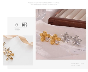 Detailed view of flower-shaped titanium steel earrings with zircon inlay in gold and silver