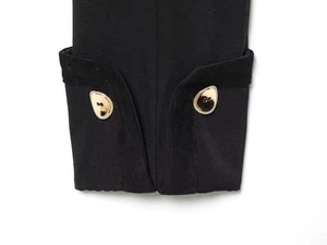 Detail of sleeve cuff with decorative irregular gold water-drop buttons on black blazer