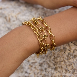 Detail shot of multi-layer thick gold-plated cable chain bracelet on a woman's wrist