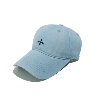 Détail d'une casquette de baseball en jean bleu clair avec broderie croix bleu marine