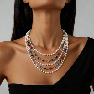 Close-up of multi-layer baroque pearl necklace with colorful gemstones and silver chains