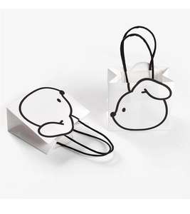 Close-up of minimalist black and white cartoon puppy pattern on paper gift bags