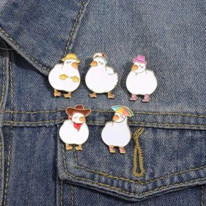 Set of cute white duck enamel pins in cartoon styles pinned on a blue denim jacket