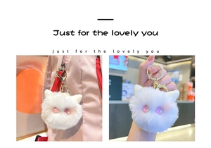 Detail of white plush cat head keychain with glittery pink eyes on a pink backpack