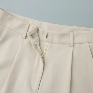 Detail showing high-quality hook-and-bar closure and zipper on beige dress trousers
