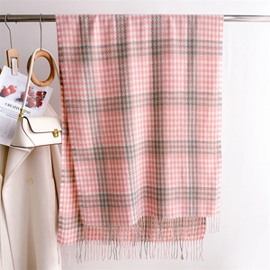 Detail of pink and grey houndstooth scarf with fringe tassels for winter fashion