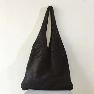 Detail showing the black hollow knitted texture and mesh pattern of the tote bag