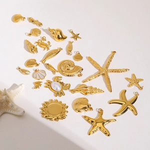 Golden stainless steel ocean pendants featuring starfish, shells and crabs on white background