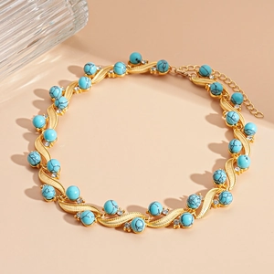 Detail of gold wave-link necklace with turquoise beads and sparkling crystals
