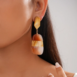 Macro detail of geometric acetic acid resin earrings with tortoiseshell marble texture