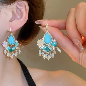 Detailed close-up of Bohemian tassel earrings with turquoise, pearls and crystals