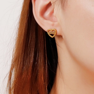 Close-up of heart-shaped gold mama stud earring worn by model for gift idea