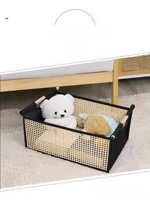Detail of hand-knitted storage basket with wooden handles and stylish black fabric edging