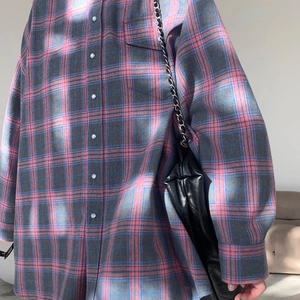 Détail d'une chemise à carreaux rose et gris avec boutonnage frontal et poche poitrine