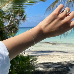 Minimalist S925 sterling silver chain bracelet shown on model against tropical beach