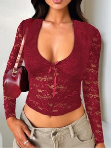 Detail of wine red lace top showing delicate floral patterns and center bow tie