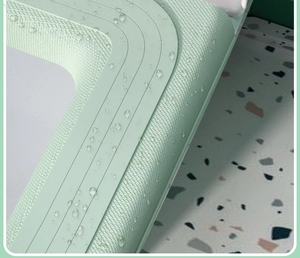 Macro shot of waterproof light green EVA toilet seat cover with water droplets on surface