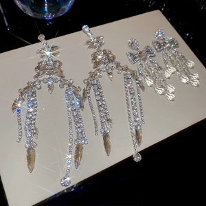 Close-up of elegant silver geometric earrings with sparkling rhinestone fringe detail