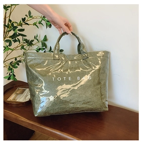 Detail of army green tote bag featuring waterproof shiny finish and crinkled paper texture
