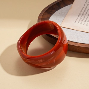 Detailed shot of dark red geometric resin bangle with vintage marble texture