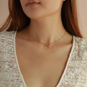 Elegant 18k gold butterfly bow pendant necklace worn by a model for a sweet stylish look