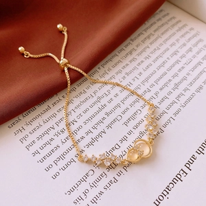Macro detail of gold-tone gourd bracelet with white zircon inlay on silk background