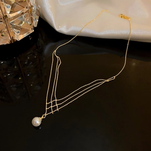 Detail shot of multi-layer gold pearl necklace on silk with crystal accents