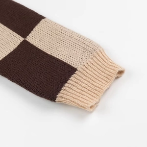 Close-up of the chunky checkerboard knit texture in dark brown and beige wool fabric