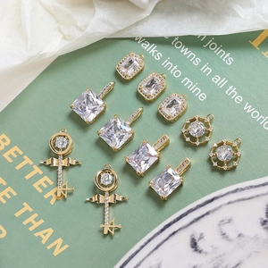 Macro shot of gold plated jewelry charms with clear zircon on a vintage book