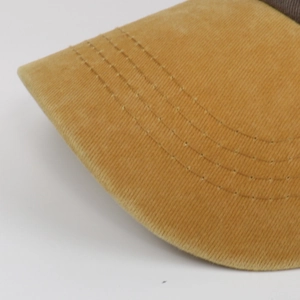 Macro shot of amber corduroy fabric texture and reinforced stitching on baseball cap brim