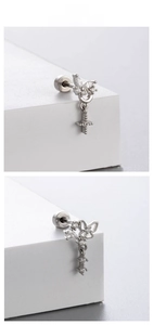 Detailed view of silver butterfly earring with cubic zirconia and cross pendant drop