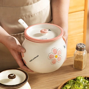 Ceramic seasoning jar with pink floral pattern, lid and spoon in a kitchen setting