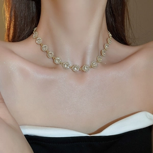 Gros plan d'un collier en or 18 carats avec zircons blancs ronds portés au cou