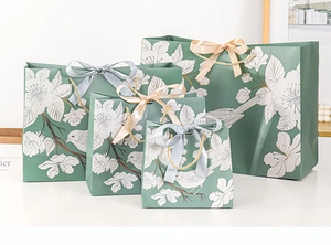 Detail of green floral gift bags with ribbon handles in four different sizes