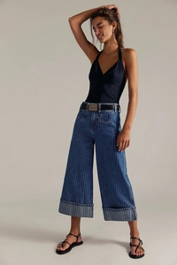 Senkrecht gestreifte Wide-Leg-Jeans mit marineblauem Neckholder-Top und schwarzem Gürtel