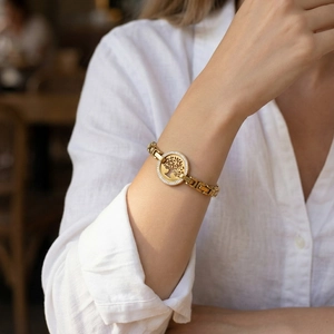Women's gold tree of life bracelet with rhinestones worn on wrist with white shirt