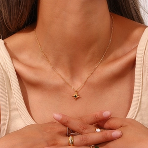 Nahaufnahme einer eleganten goldenen Sternenkette mit schwarzem Stein am Model