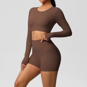 Detail van de yoga-shorts met hoge taille en zijzak en crop-top met lange mouwen in bruin
