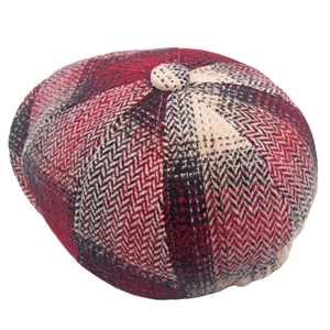 Detailed macro view of the vintage red herringbone newsboy cap fabric and top button