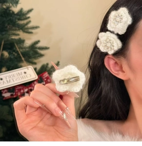 Detailed view of handmade knitted flower hair clip with pearl center and metal duckbill clip