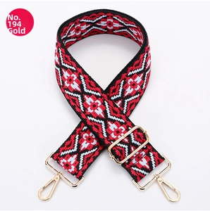Detail of red and black geometric ethnic woven bag strap with golden metal snap hooks
