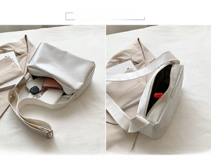 Macro detail of white PU leather tote bag showing interior main compartment and capacity