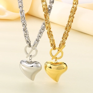Close-up of Byzantine style heart necklaces in gold and silver with OT toggle clasp